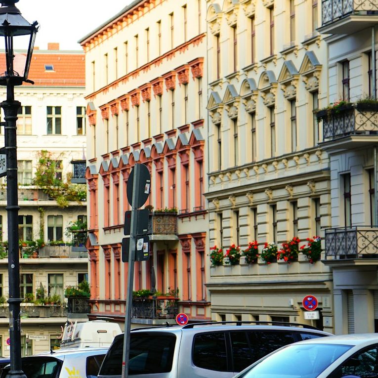 Bunte Altbausiedlung mit Blumenbalkonen in einer städtischen Umgebung.