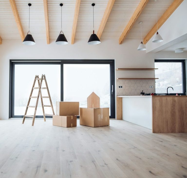 Helle, moderne Innenräume mit Leitern und Umzugskartons. Großer Fensterbereich.
