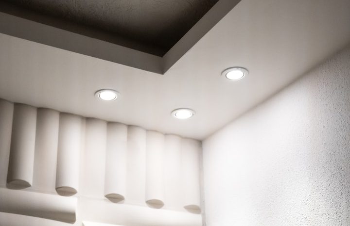 Drei runde Deckenleuchten in einem modernen, hellen Raum mit einer strukturierten Wand.